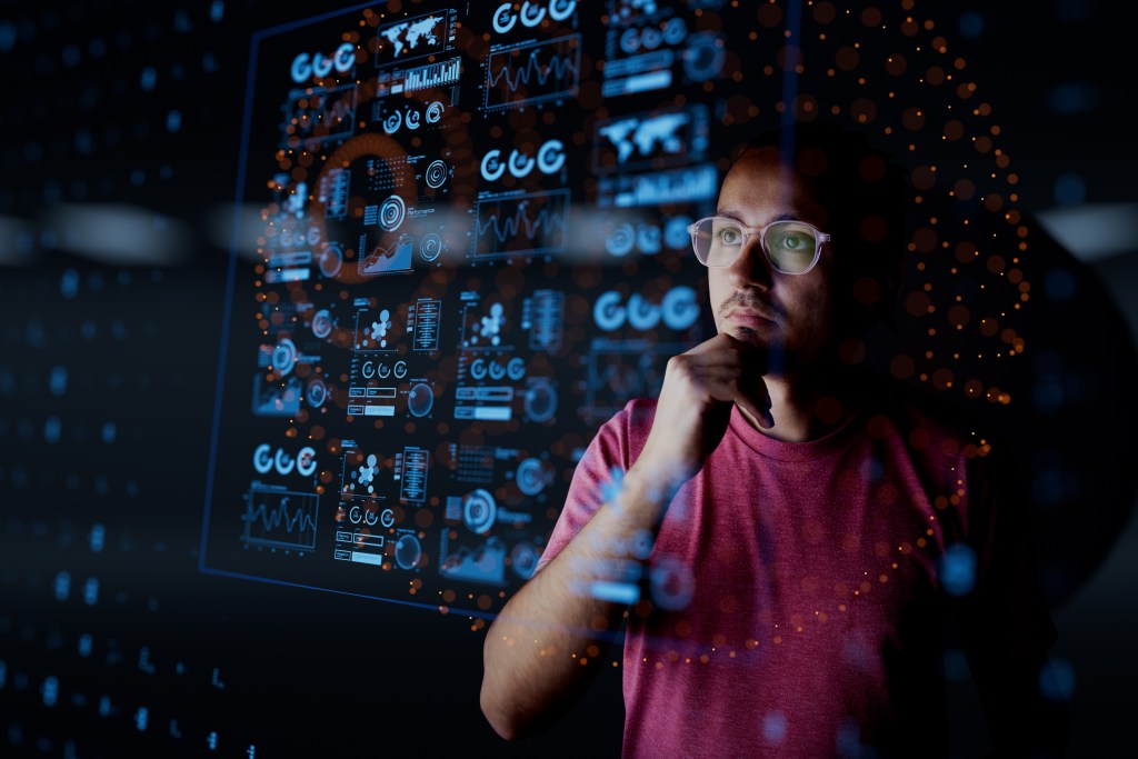 Fotografía de trabajador analizando datos de automatización presentados en una pantalla